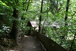 Zugang über die überdachte Holzbrücke zu den Mühlen